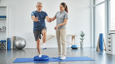 Patient, der an Gleichgewichtsübungen in einer Therapieeinheit teilnimmt